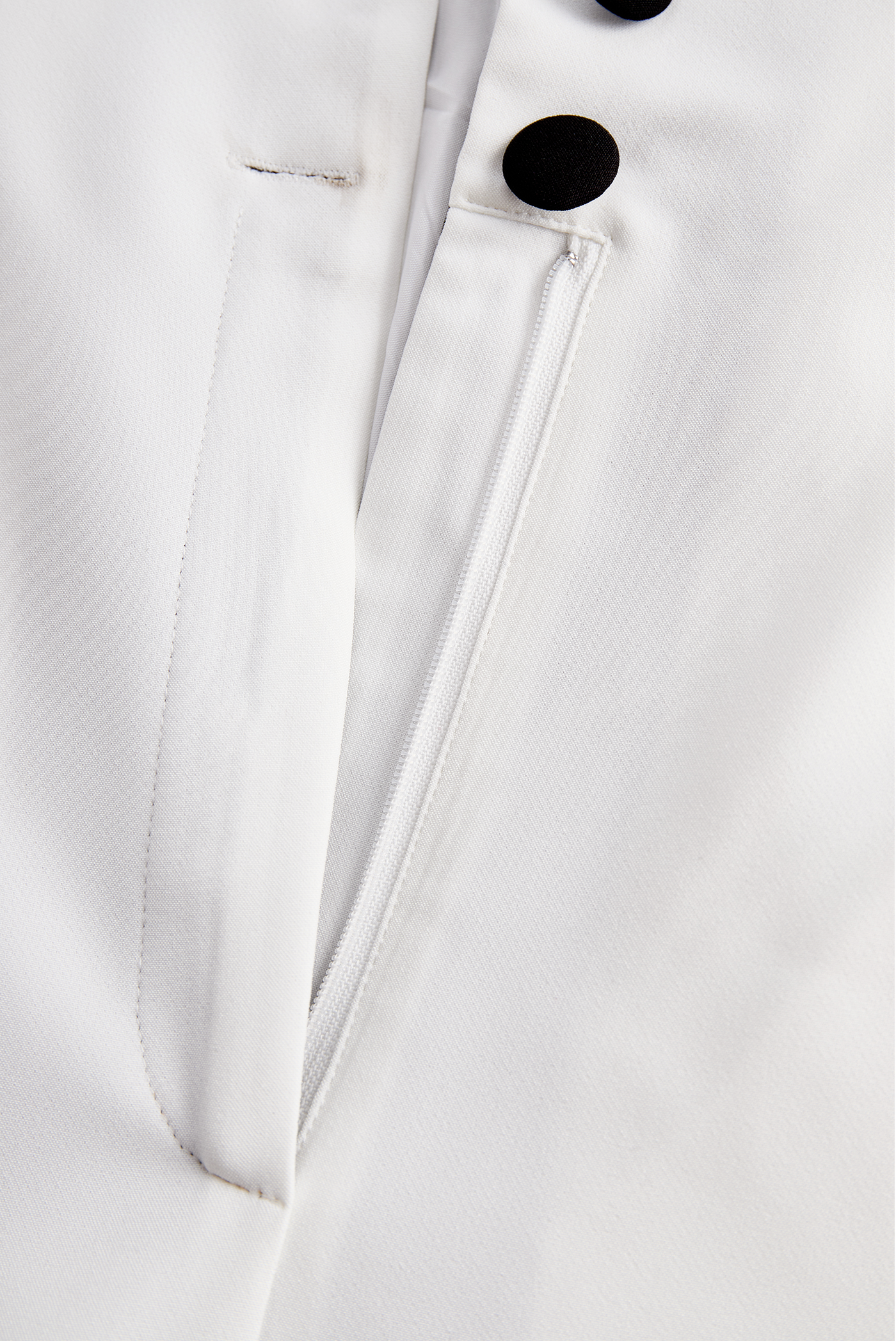 Sleek White Jumpsuit With Dual Button Detail And Black Lapel